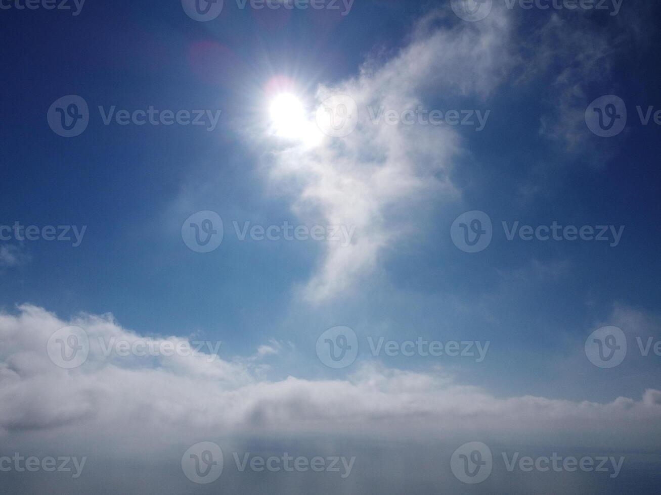 Aerial view. The drone flies over foggy and fluffy clouds. Blue sky sun and sea fog. Abstract aerial nature summer ocean sunset sea and sky background. Vacation, travel and holiday concept photo