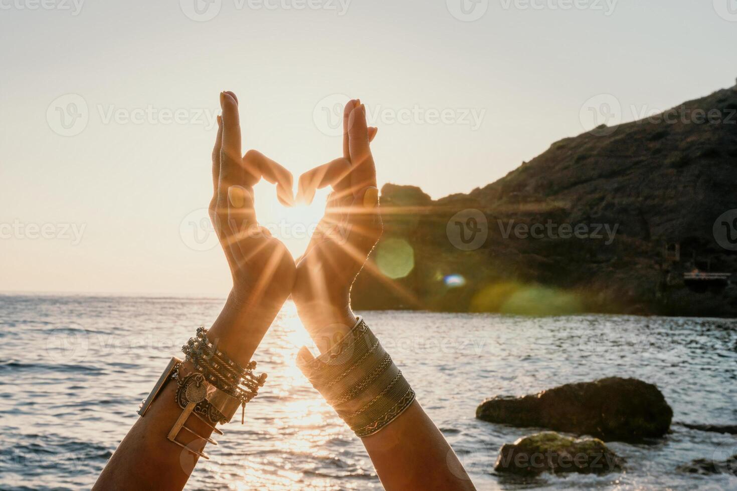Woman sea yoga. Happy woman in white swimsuit and boho style braclets practicing outdoors on yoga mat by sea on sunset. Women yoga fitness routine. Healthy lifestyle, harmony and meditation photo