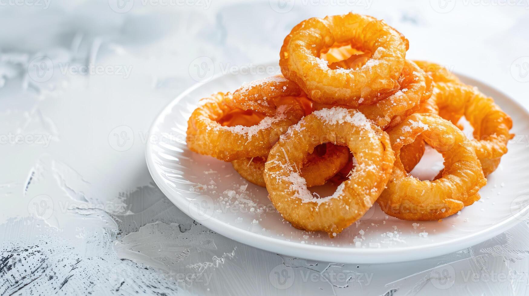 Golden breaded and deep fried crispy onion rings on white plate photo