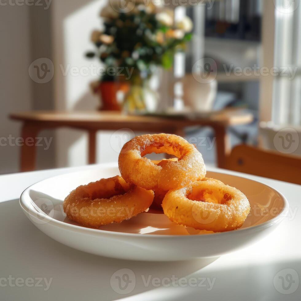 Golden breaded and deep fried crispy onion rings on white plate in the dining room photo
