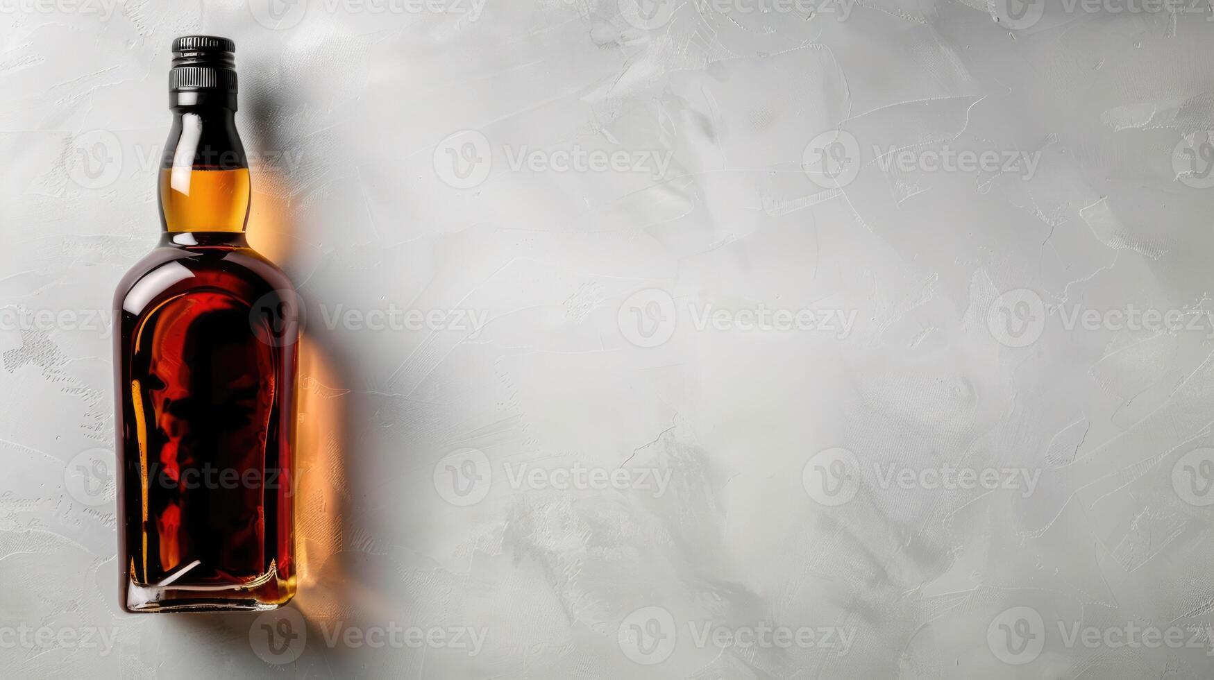 Whiskey or brandy bottle, alcohol drink isolated on grey background with copy space photo