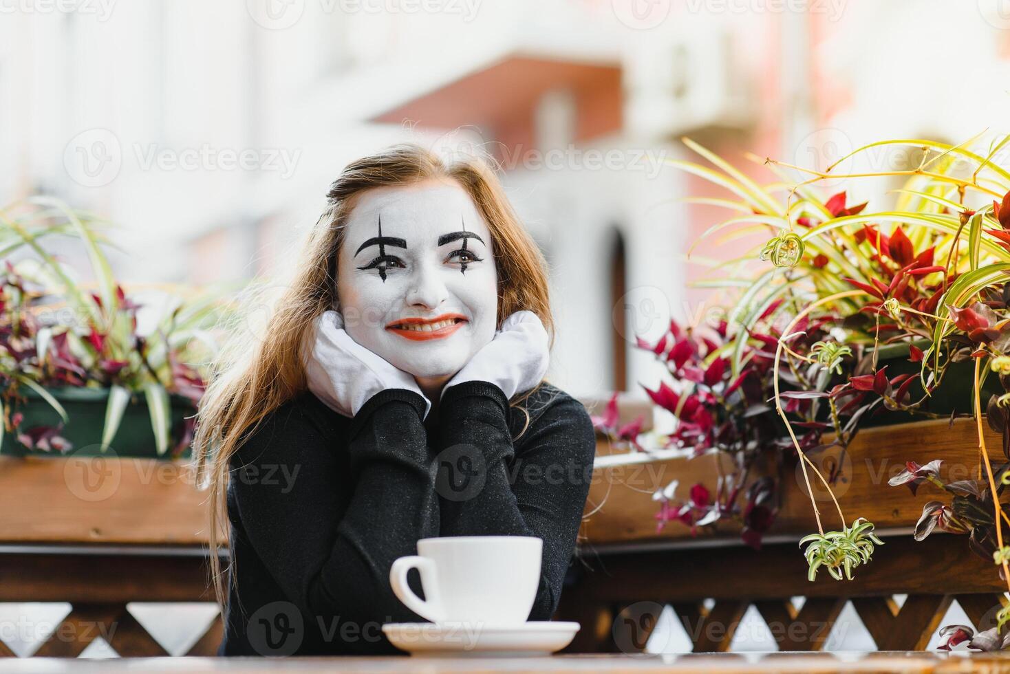 Mime comedian drinking coffee. girl mime drinks coffee in paris. photo