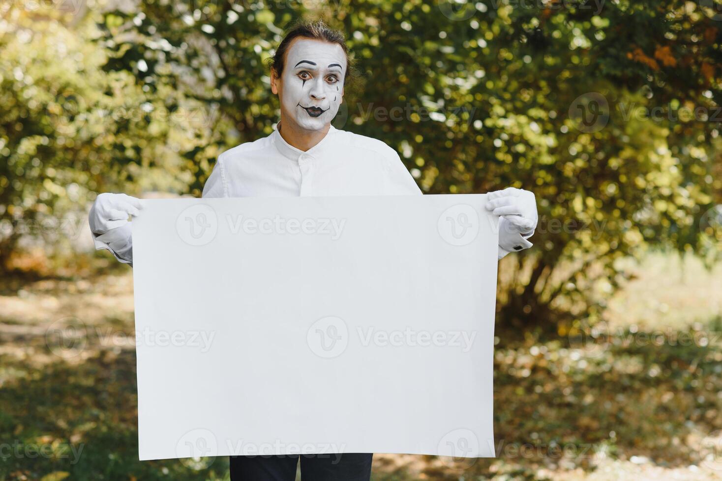 Your text here. Actors mimes holding empty white letter. Colorful portrait with green background. April fools day photo