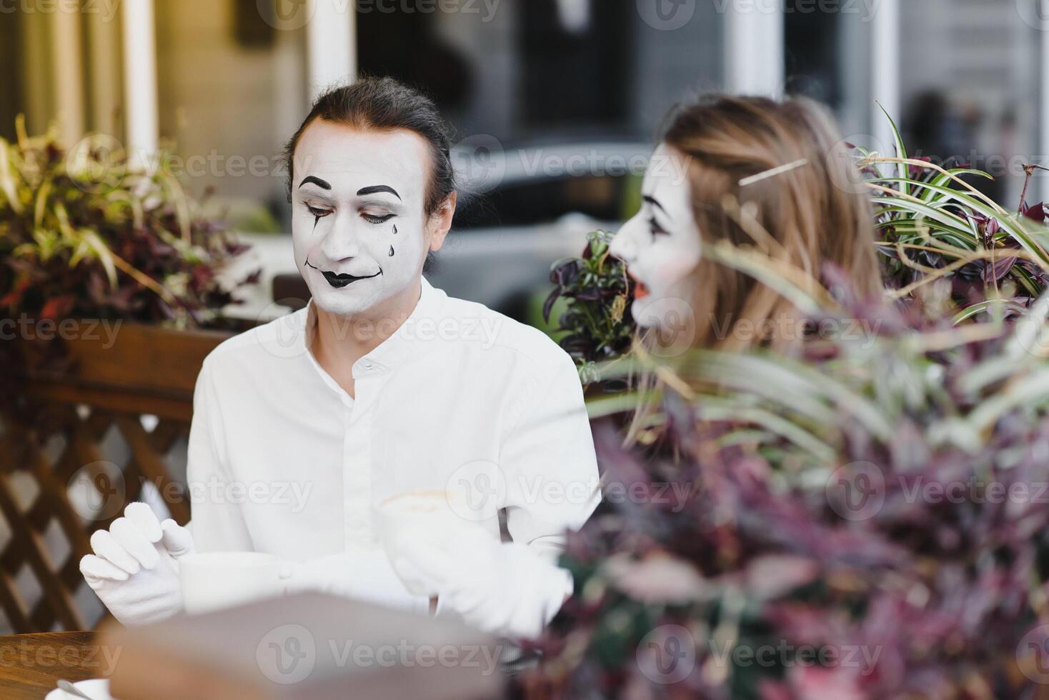 Mimes in front of Paris cafe acting like drinking tea or coffee. photo
