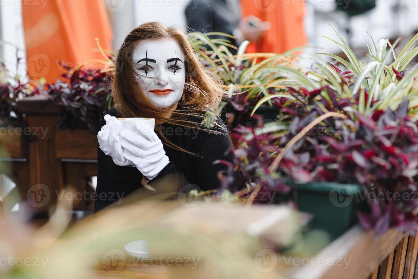 Mime comedian drinking coffee. girl mime drinks coffee in paris. photo