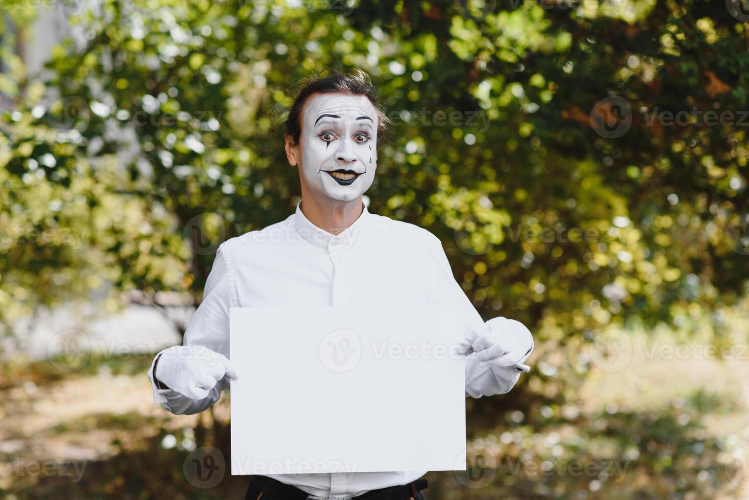 Your text here. Actors mimes holding empty white letter. Colorful portrait with green background. April fools day photo