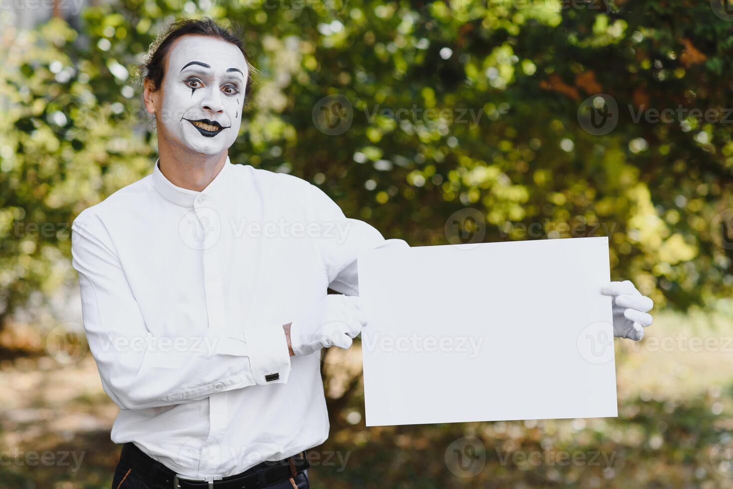 Your text here. Actors mimes holding empty white letter. Colorful portrait with green background. April fools day photo