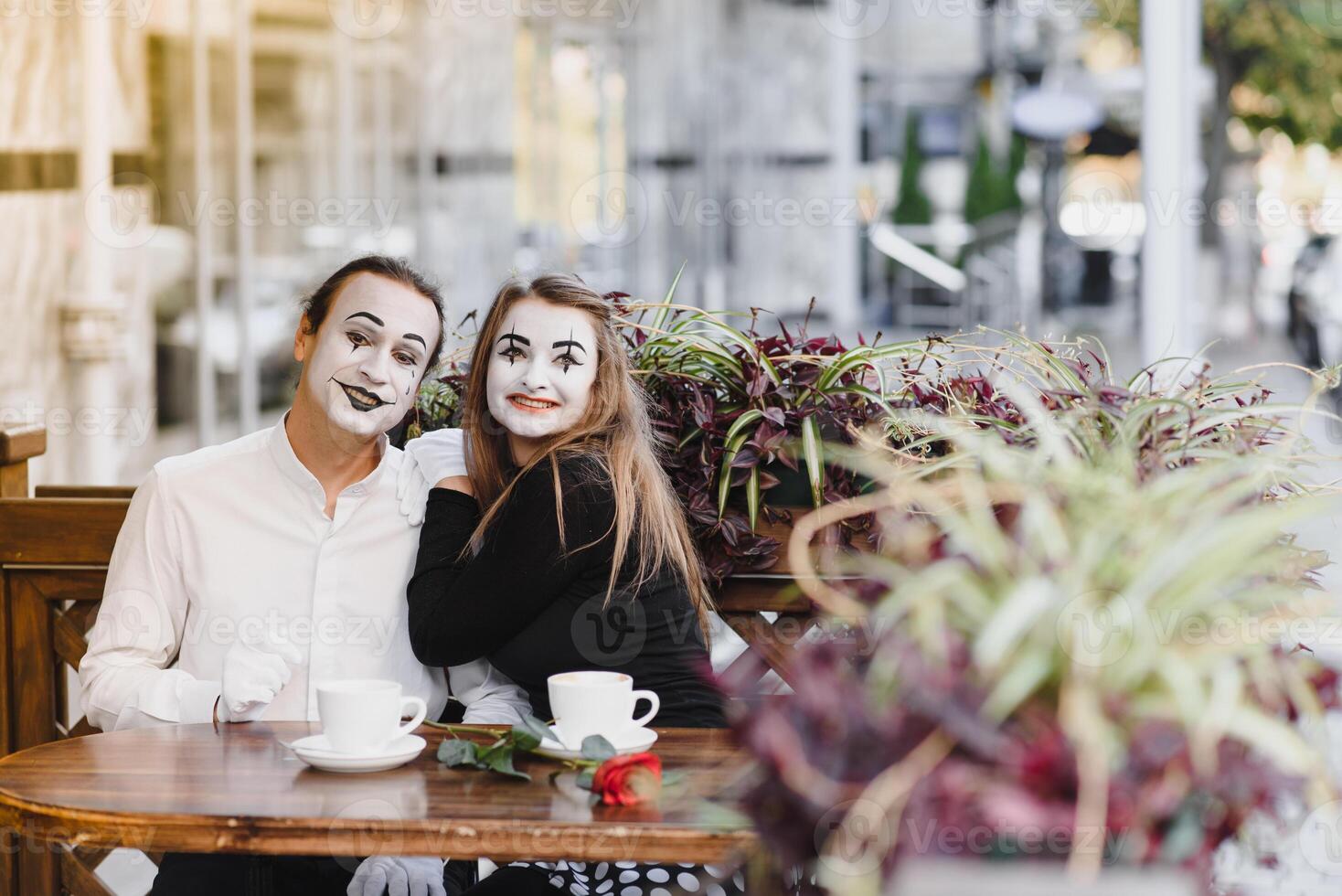 Mimes in front of Paris cafe acting like drinking tea or coffee. photo