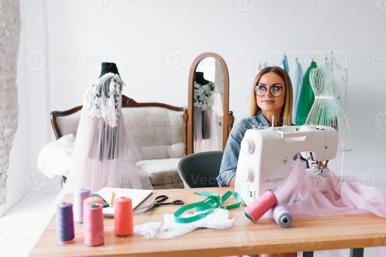 Working on new collection. New order. Female fashion designer works on the new clothes in the workshop. photo