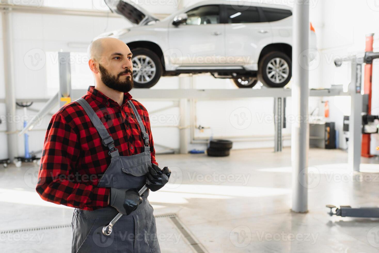 Mechanic working and holding wrench of service order for maintaining car at the repair shop photo