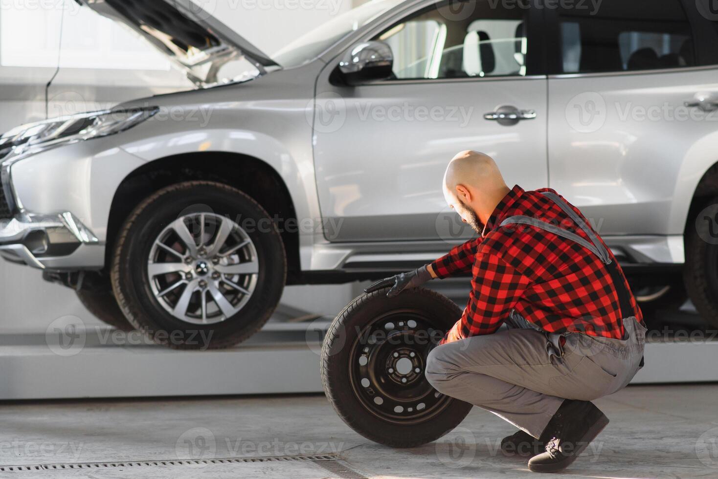 Man repairing a car wheel in a garage photo