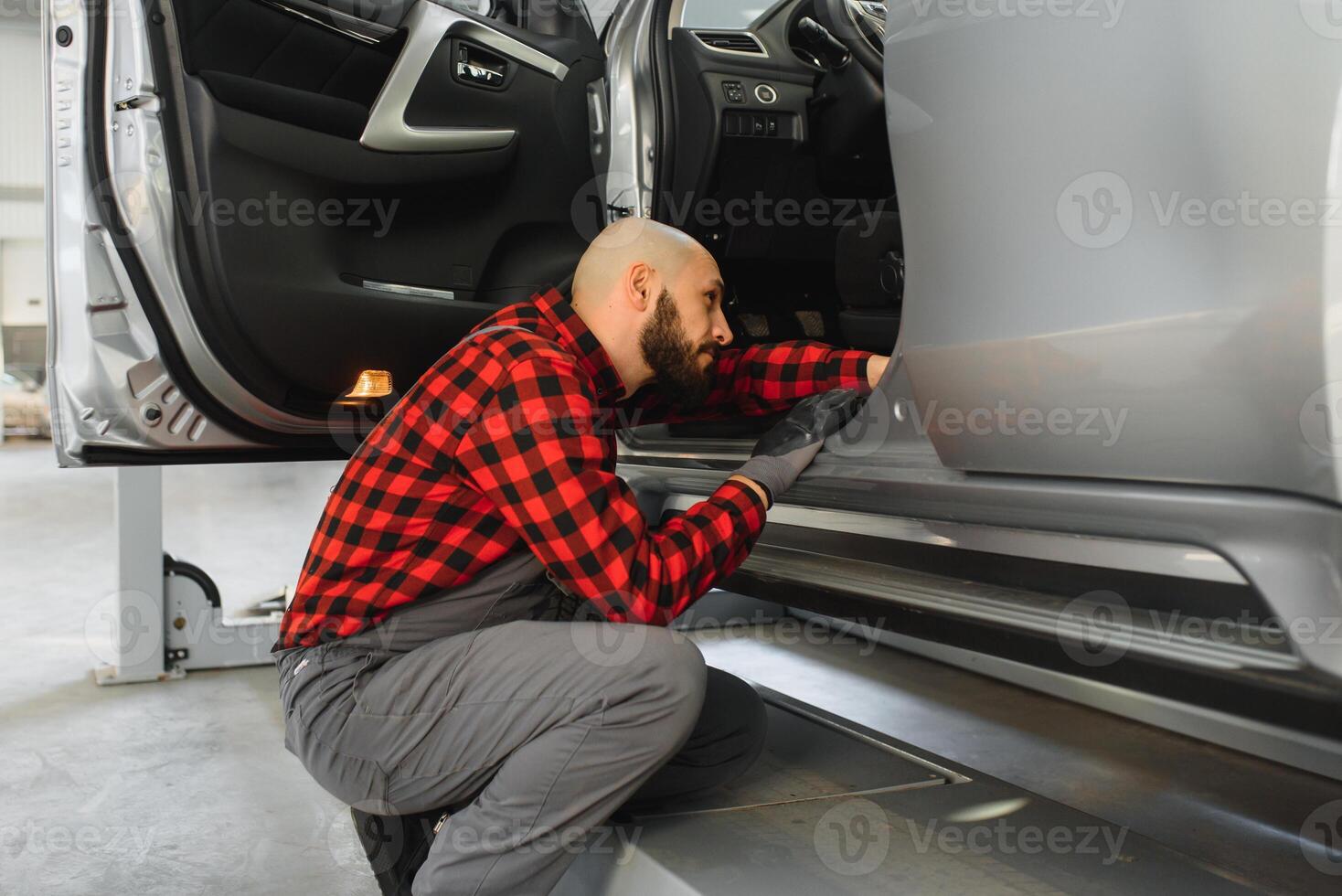 Mechanic working and holding wrench of service order for maintaining car at the repair shop photo