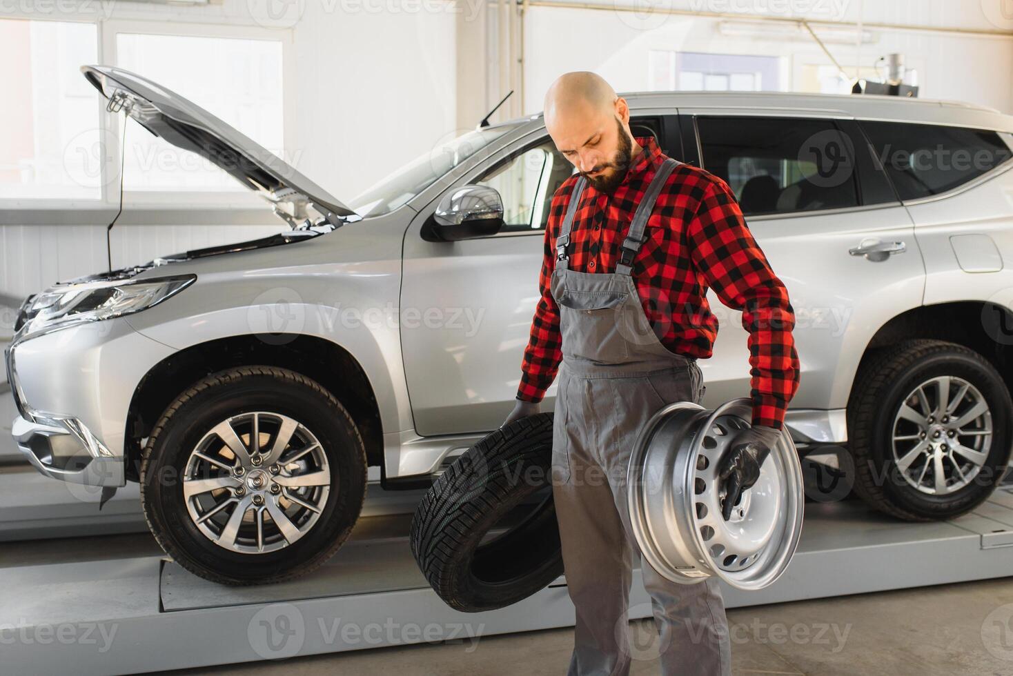Mechanic holding a tire tire at the repair garage. replacement of winter and summer tires. photo