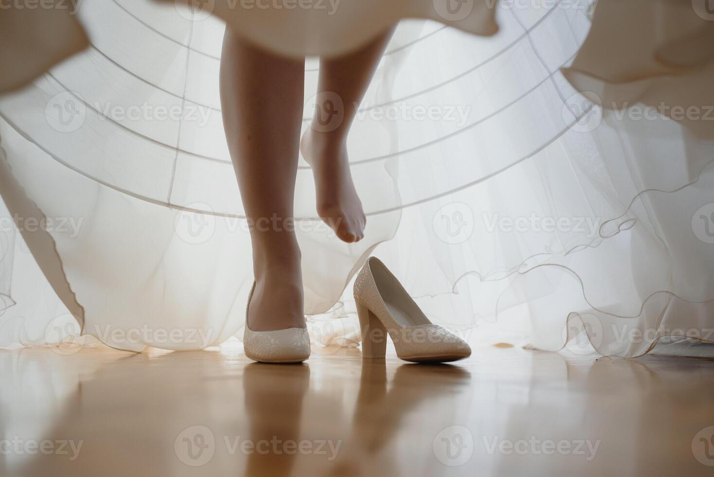 Bridesmaid helping slender bride lacing her wedding white dress, buttoning on delicate lace pattern with fluffy skirt on waist. Morning bridal preparation details newlyweds. Wedding day moments, wear. photo