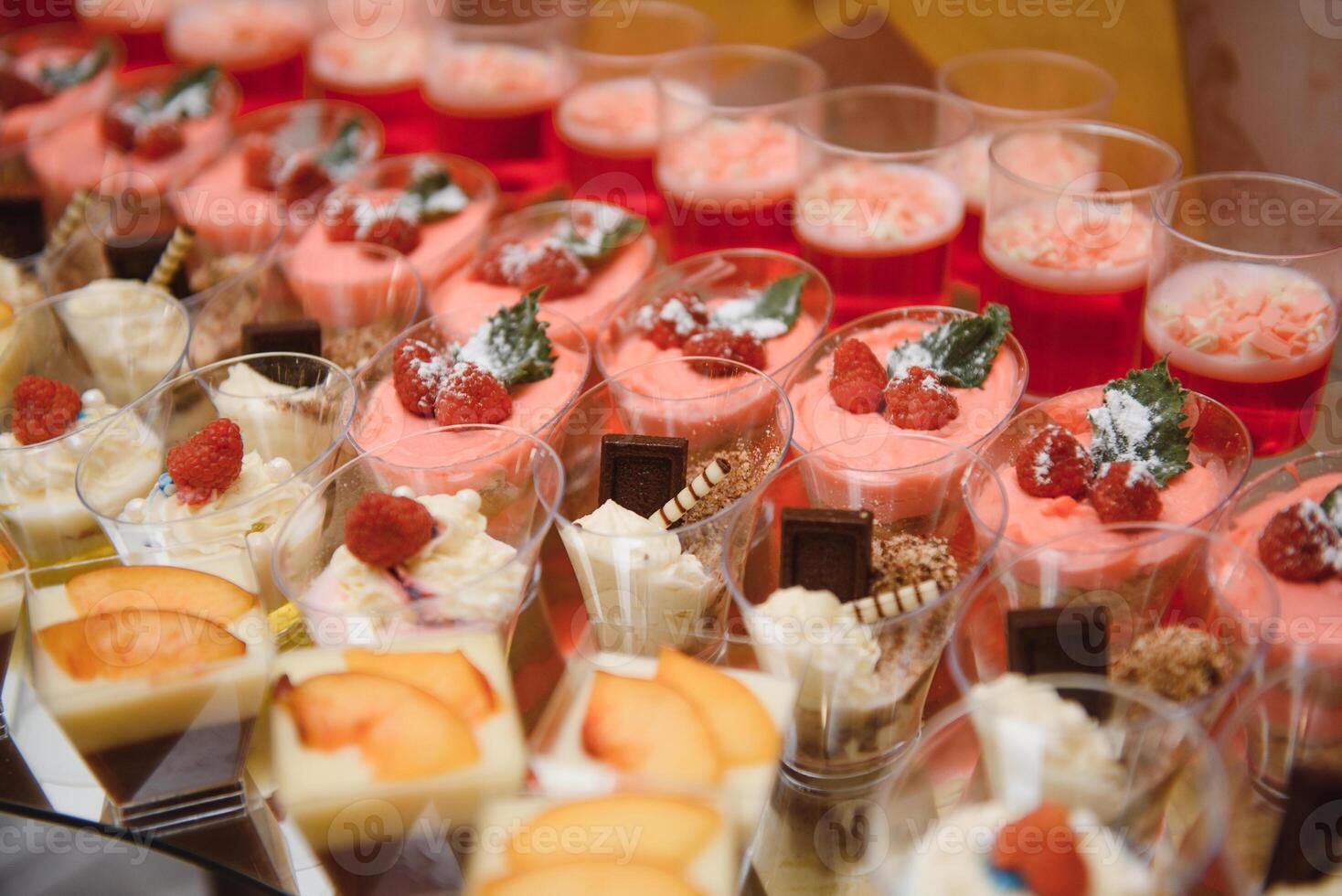 desserts with fruits, mousse, biscuits. Different types of sweet pastries, small colorful sweet cakes, macaron, and other desserts in the sweet buffet. candy bar for birthday photo