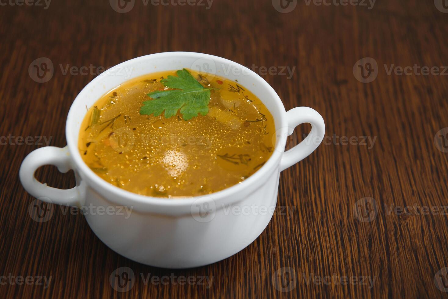 A picture of a bowl of traditional chicken soup served in a bowl over wooden background photo