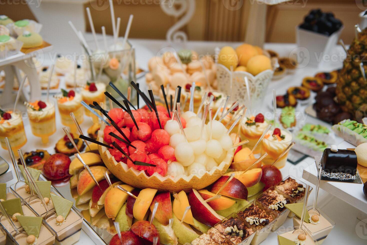 desserts with fruits, mousse, biscuits. Different types of sweet pastries, small colorful sweet cakes, macaron, and other desserts in the sweet buffet. candy bar for birthday photo