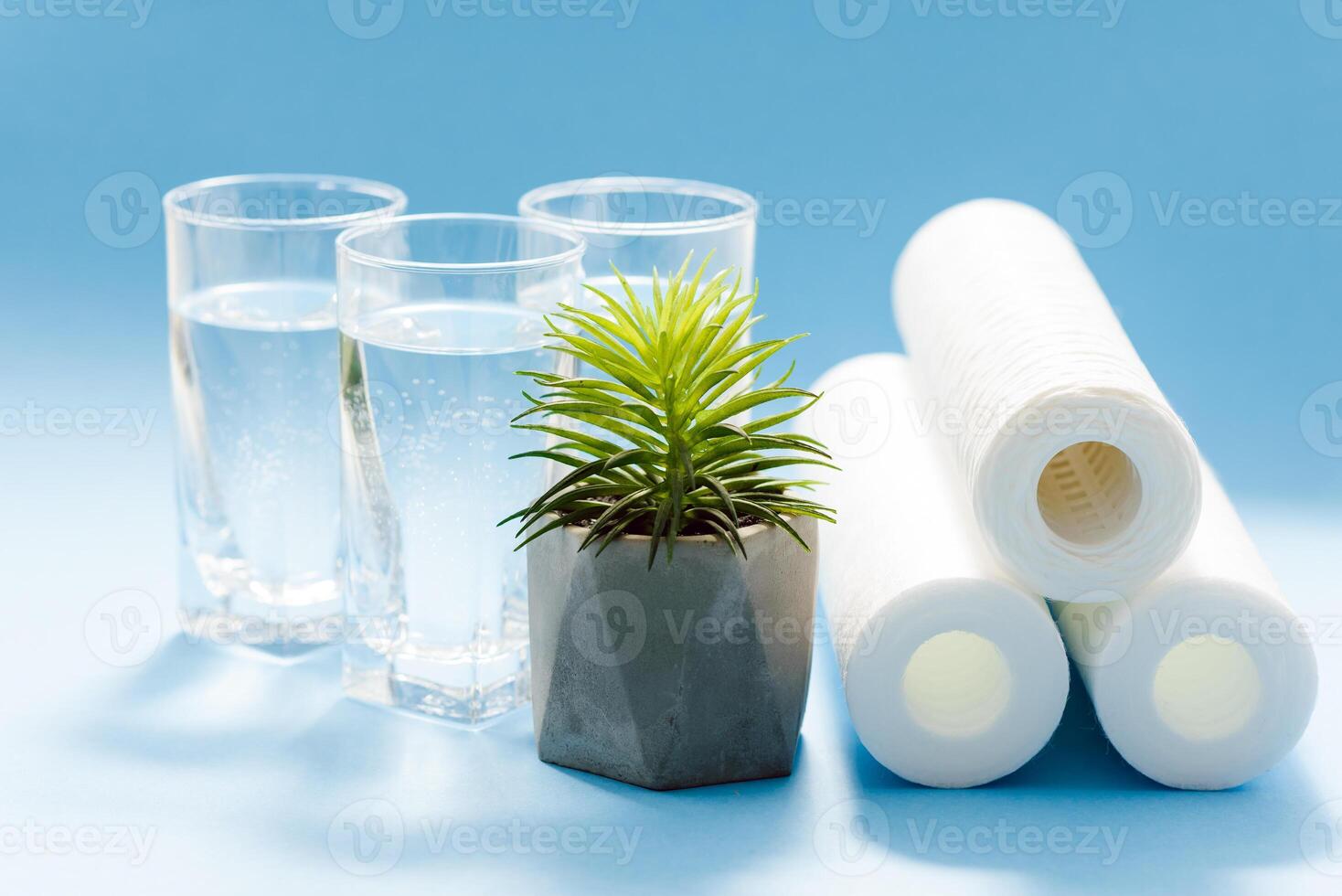 Water filters. Carbon cartridges and glasses on a blue background. Household filtration system. photo