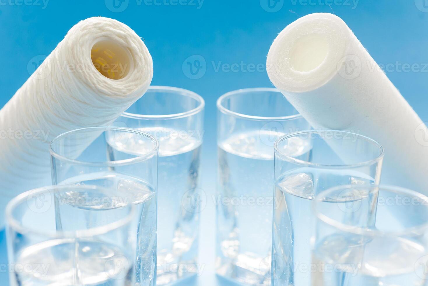 Line of glasses, a glass with water, on a light blue background. Difference concept. Equality concept. photo