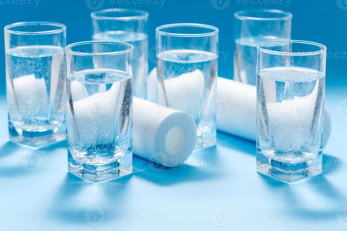 A glass of water on the background of filter cartridges photo