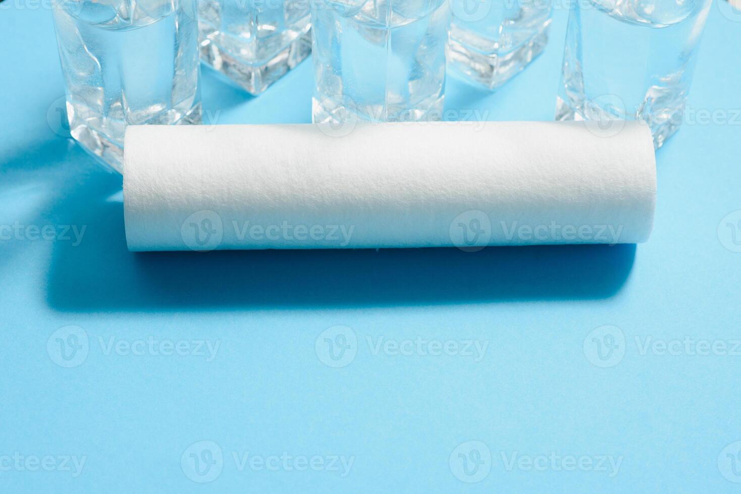 Water filters. Carbon cartridges and glasses on a blue background. Household filtration system. photo