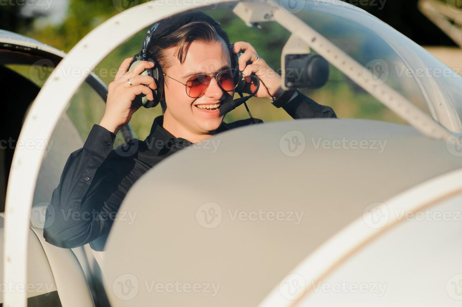 Portrait of confident young man pilot in small plane photo