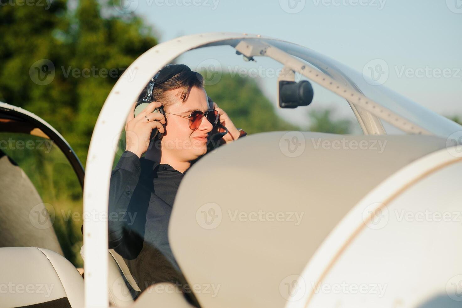Portrait of confident young man pilot in small plane photo