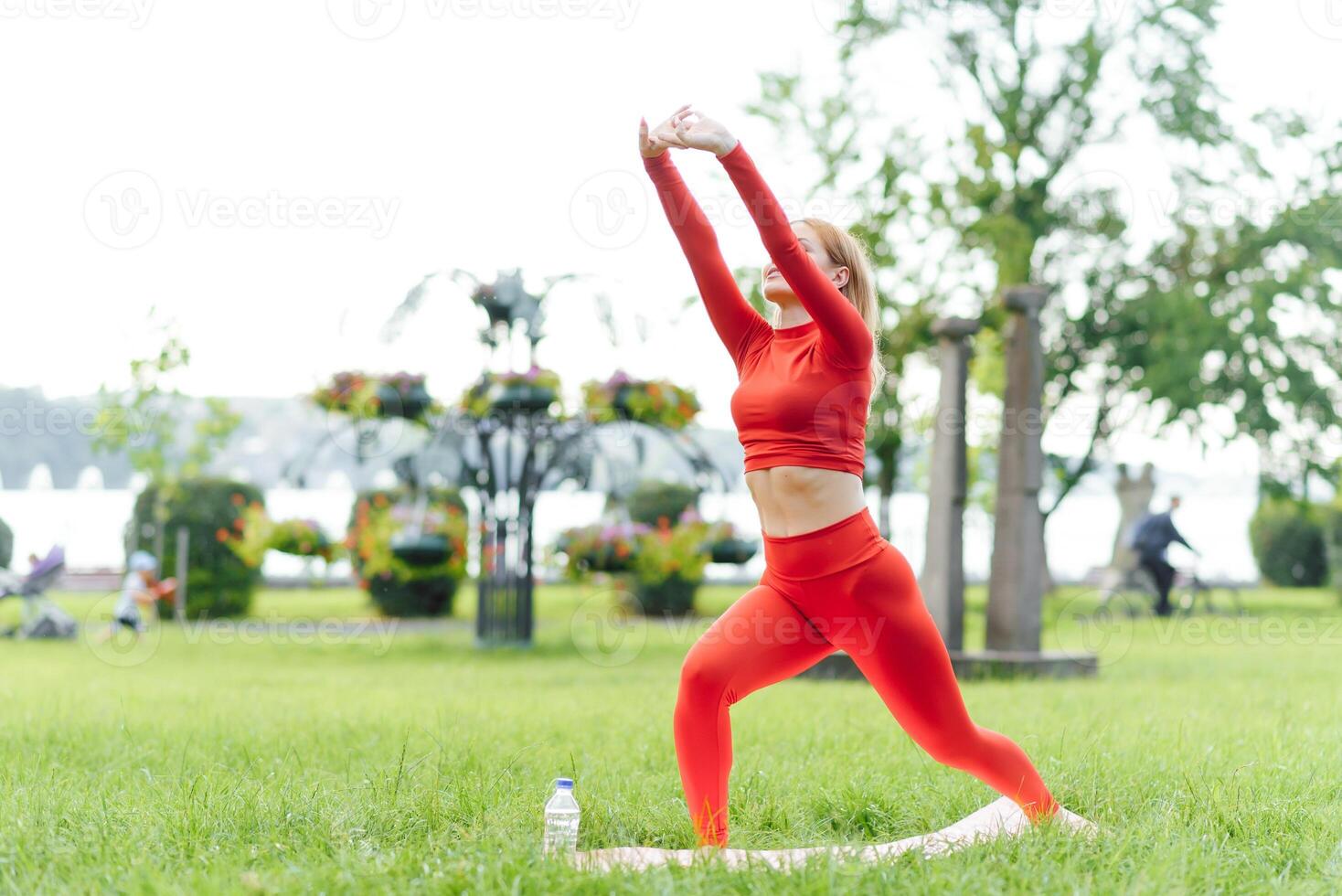 Young woman doing yoga exercise in green park photo