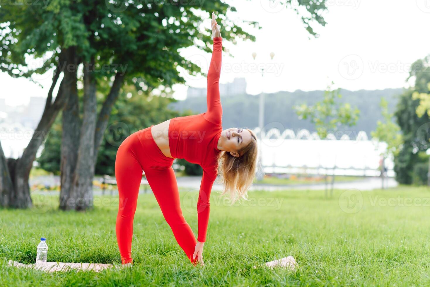 Young female workout before fitness training session at the park. Healthy young woman warming up outdoors. She is stretching her arms and looking away,hi key. photo