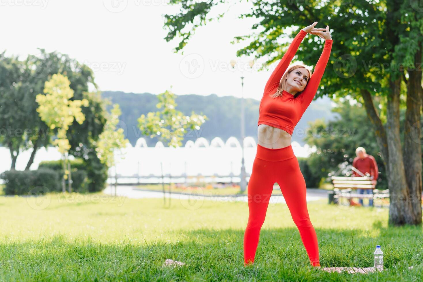 Young woman doing yoga exercise in green park photo