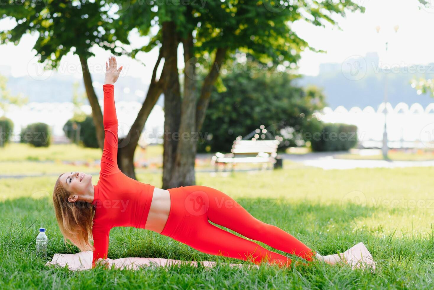 Young woman doing yoga exercise in green park photo