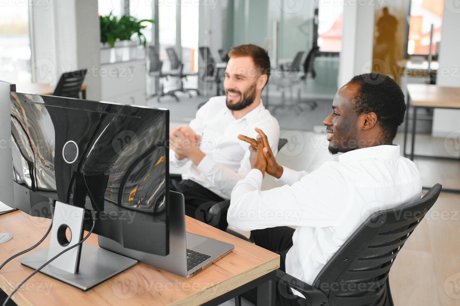 Two successful trader sitting in office, checking cryptocurrency information data on finance market graph, pointing on monitor photo