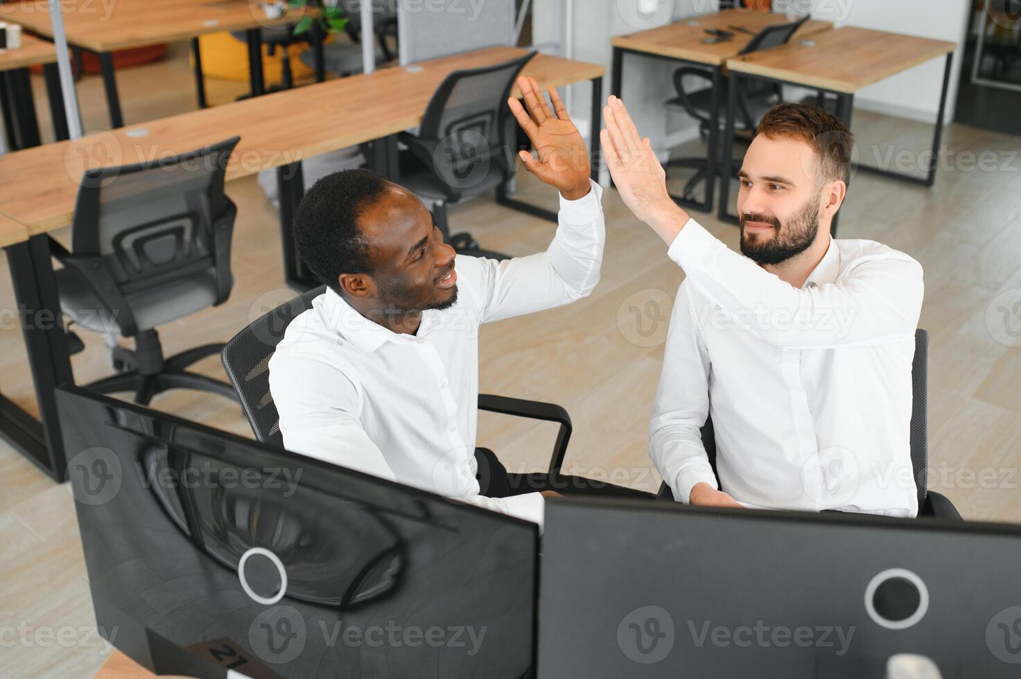 Two successful trader sitting in office, checking cryptocurrency information data on finance market graph, pointing on monitor photo