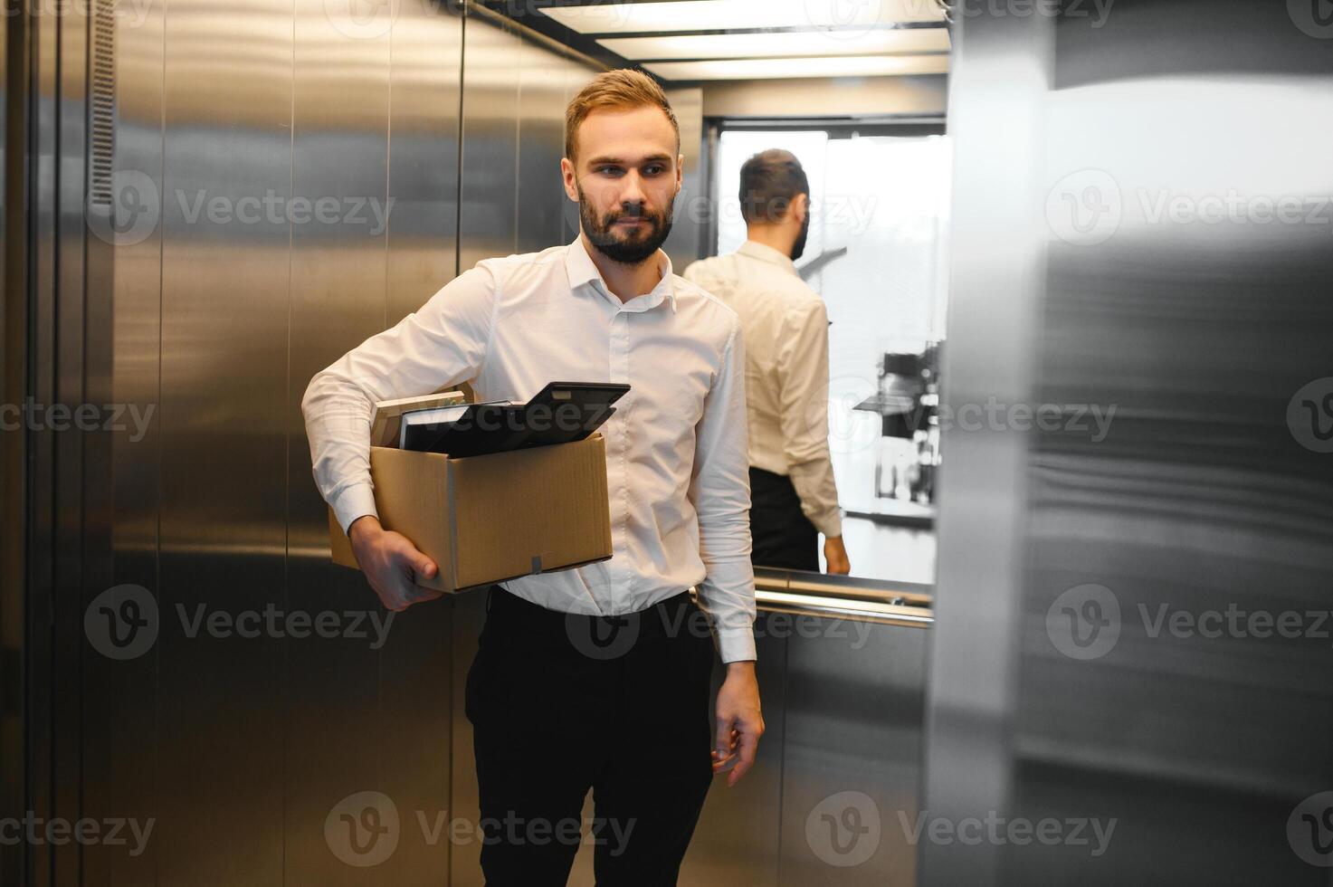 Man by dismissal. Guy lost job. Fired manager in company. Dismissal box in hands of employee. photo