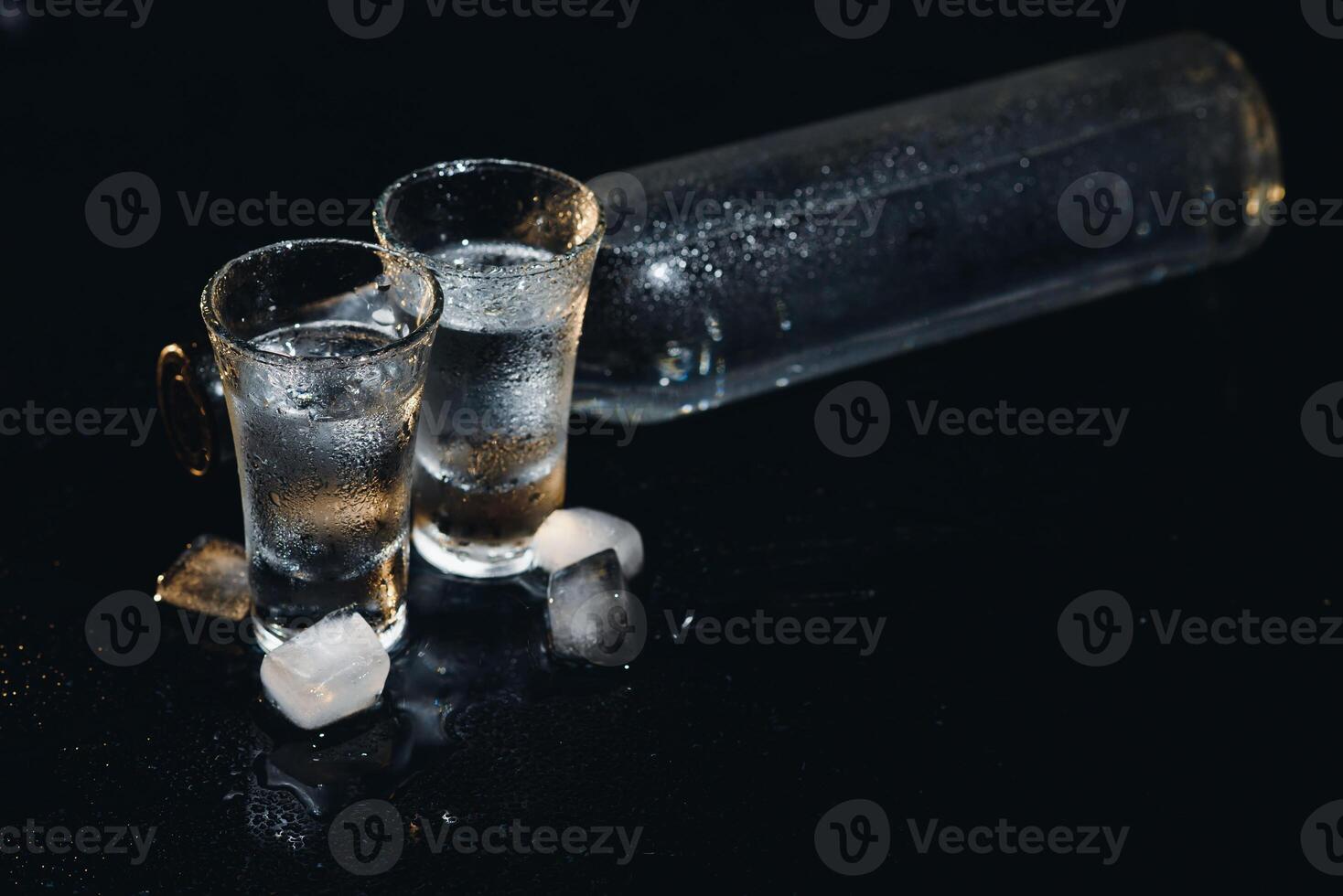 Vodka. Shots, glasses with vodka with ice .Dark background. Copy space .Selective focus. photo