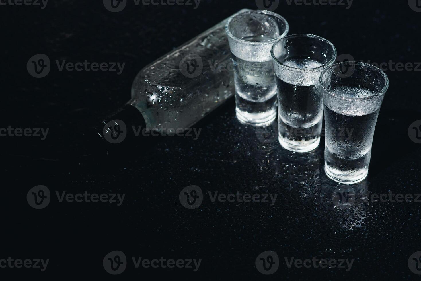 Vodka. Shots, glasses with vodka with ice .Dark background. Copy space .Selective focus. photo