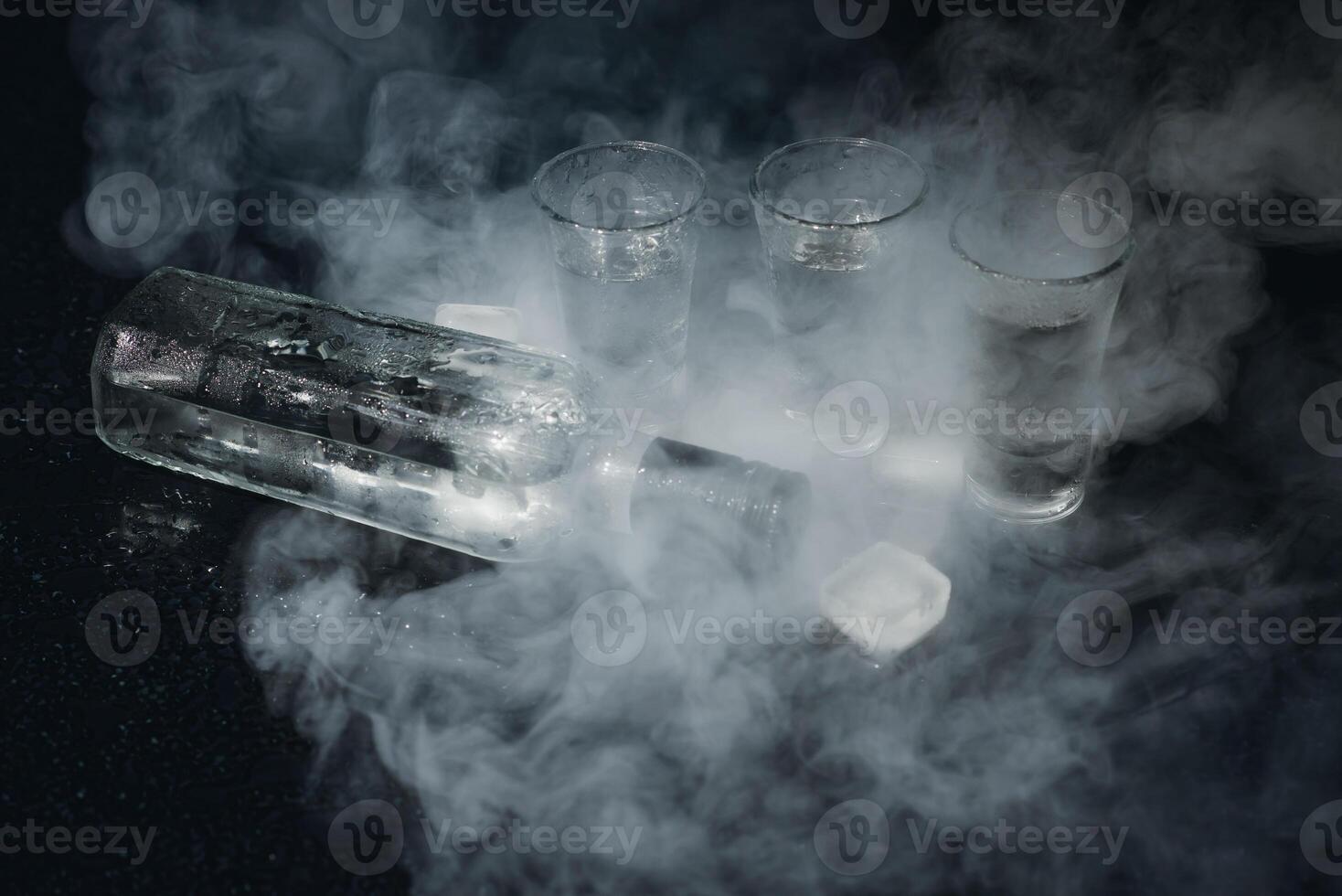 Cold vodka in shot glasses on a black background. Top view. Food background. photo