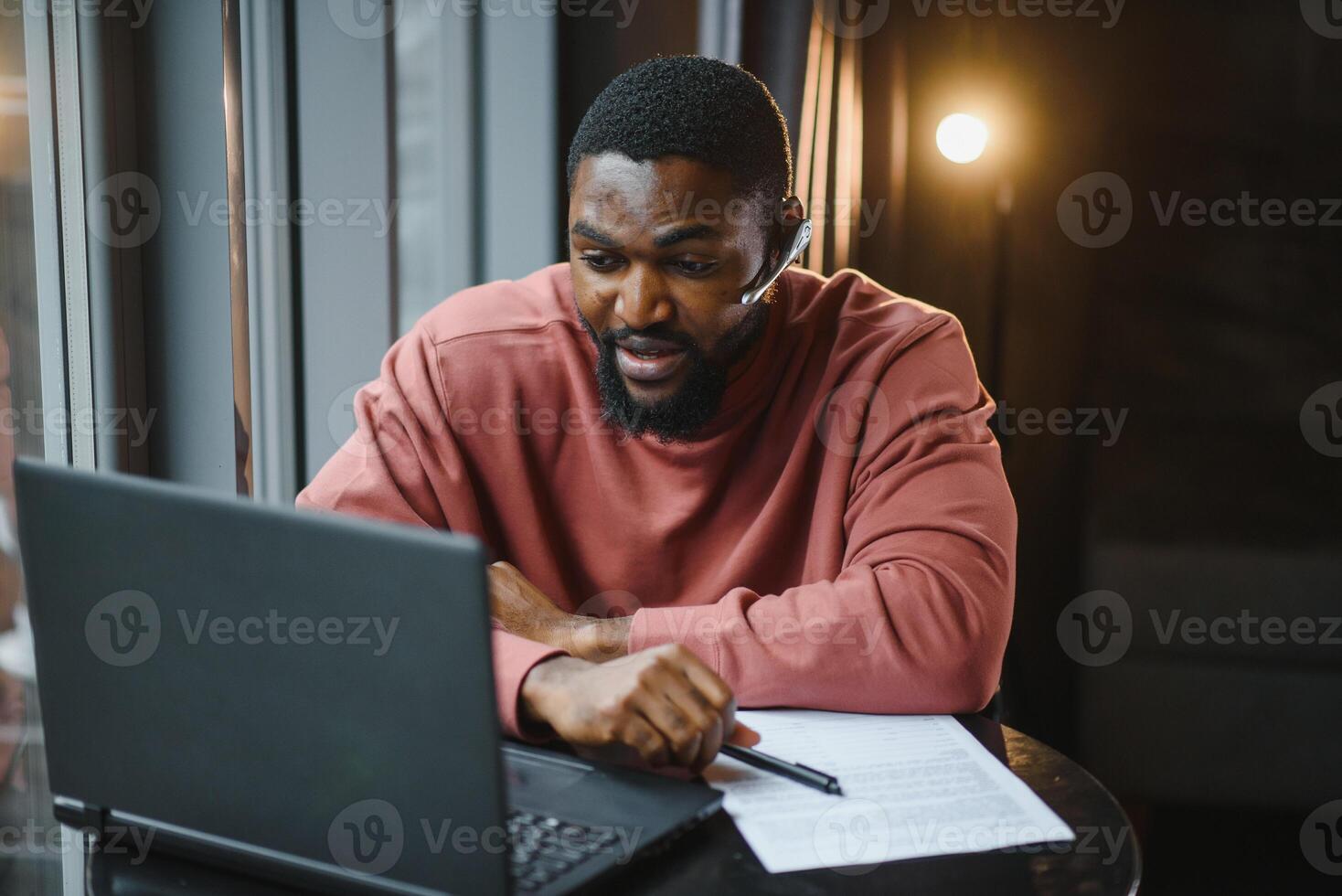 Afro american talks chat on computer sits in cafe with cup of coffee. Black man calls on laptop on link and speaks. He wears in shirt and suit jacket. link online connection photo