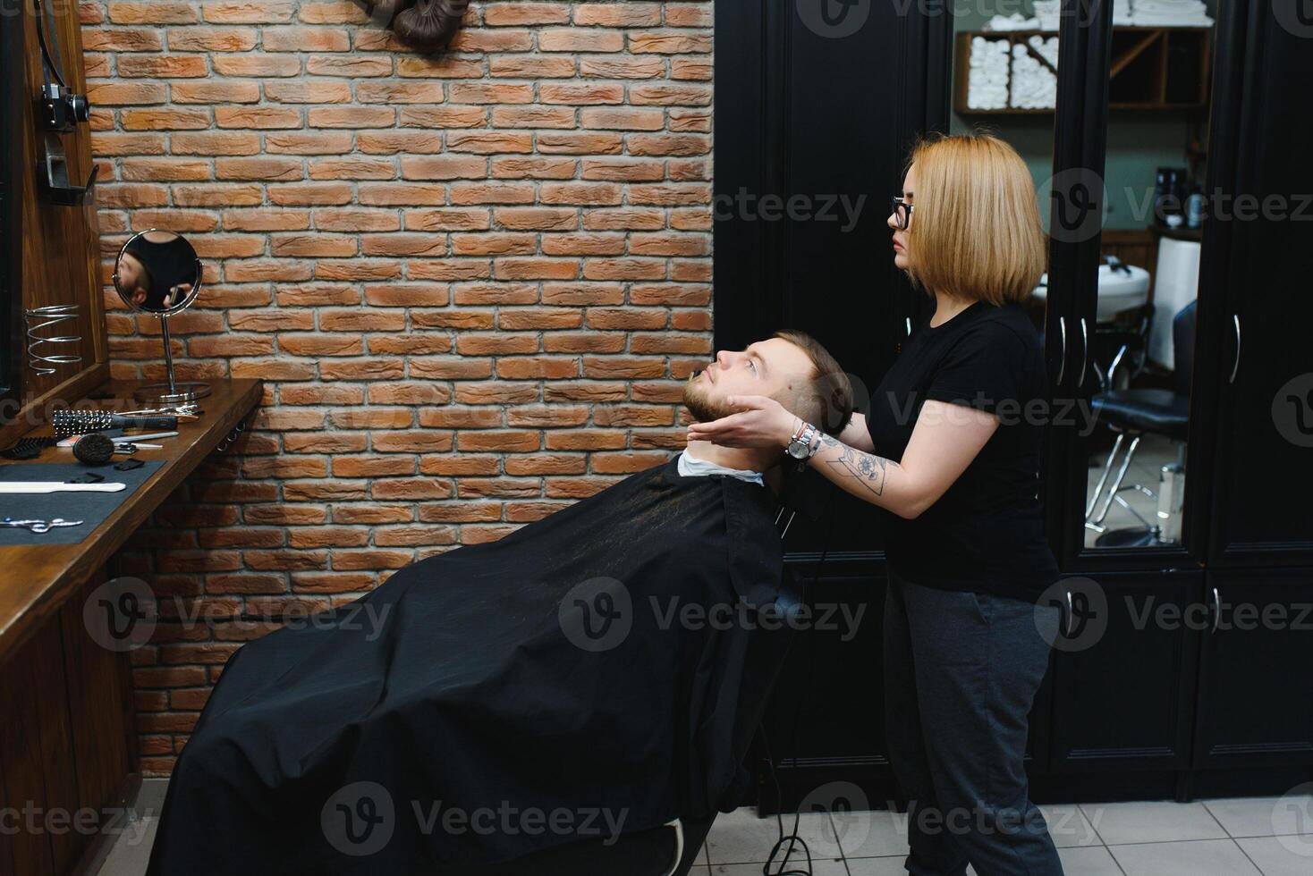 Barbershop or hairdresser concept. Woman hairdresser cuts beard with scissors. Man with long beard, mustache and stylish hair. Guy with modern hairstyle visiting hairdresser photo