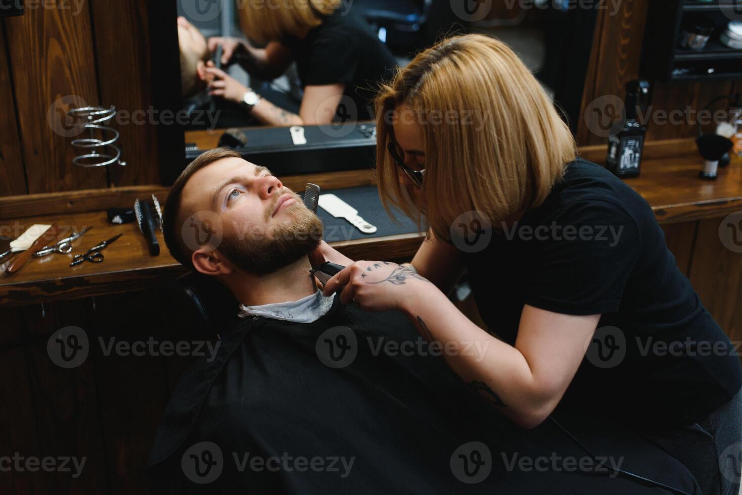 Client during beard shaving in barber shop photo
