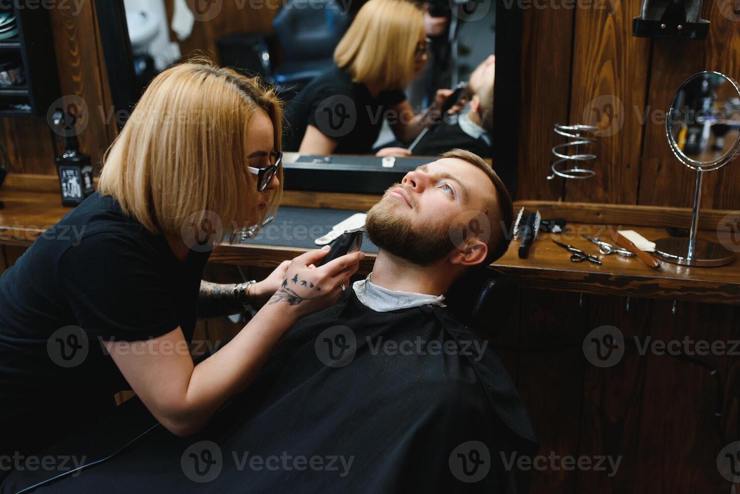 Client during beard shaving in barber shop photo