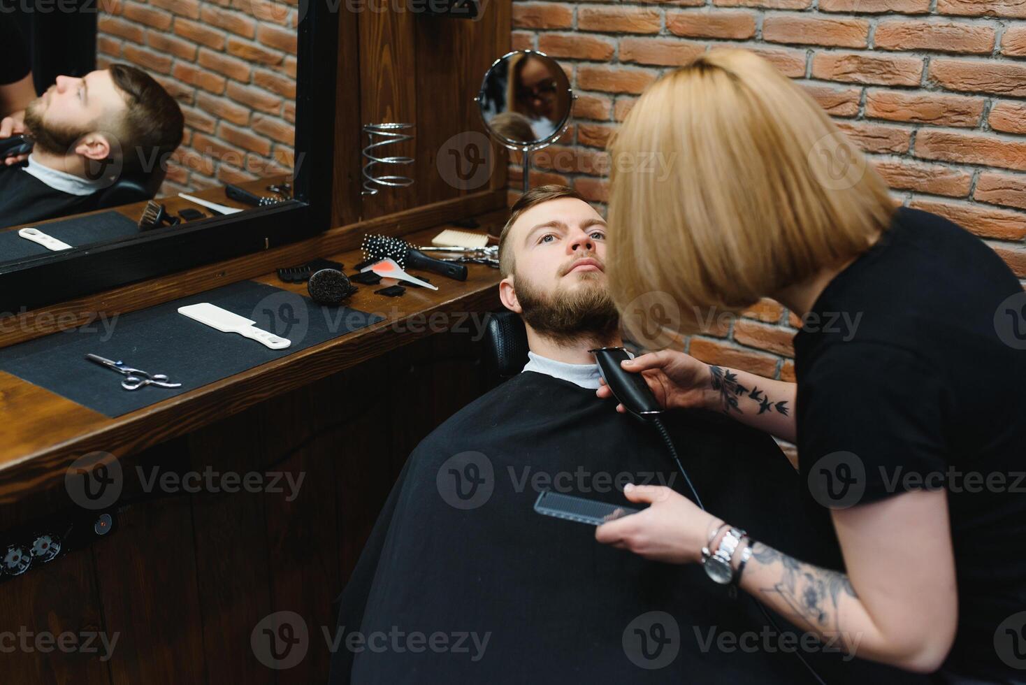 Client during beard shaving in barber shop photo