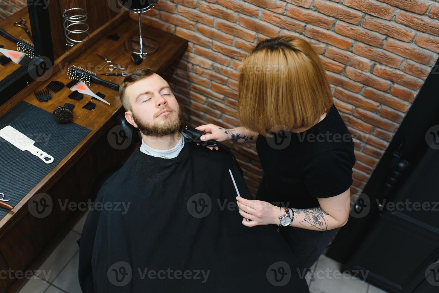 Client during beard shaving in barber shop photo