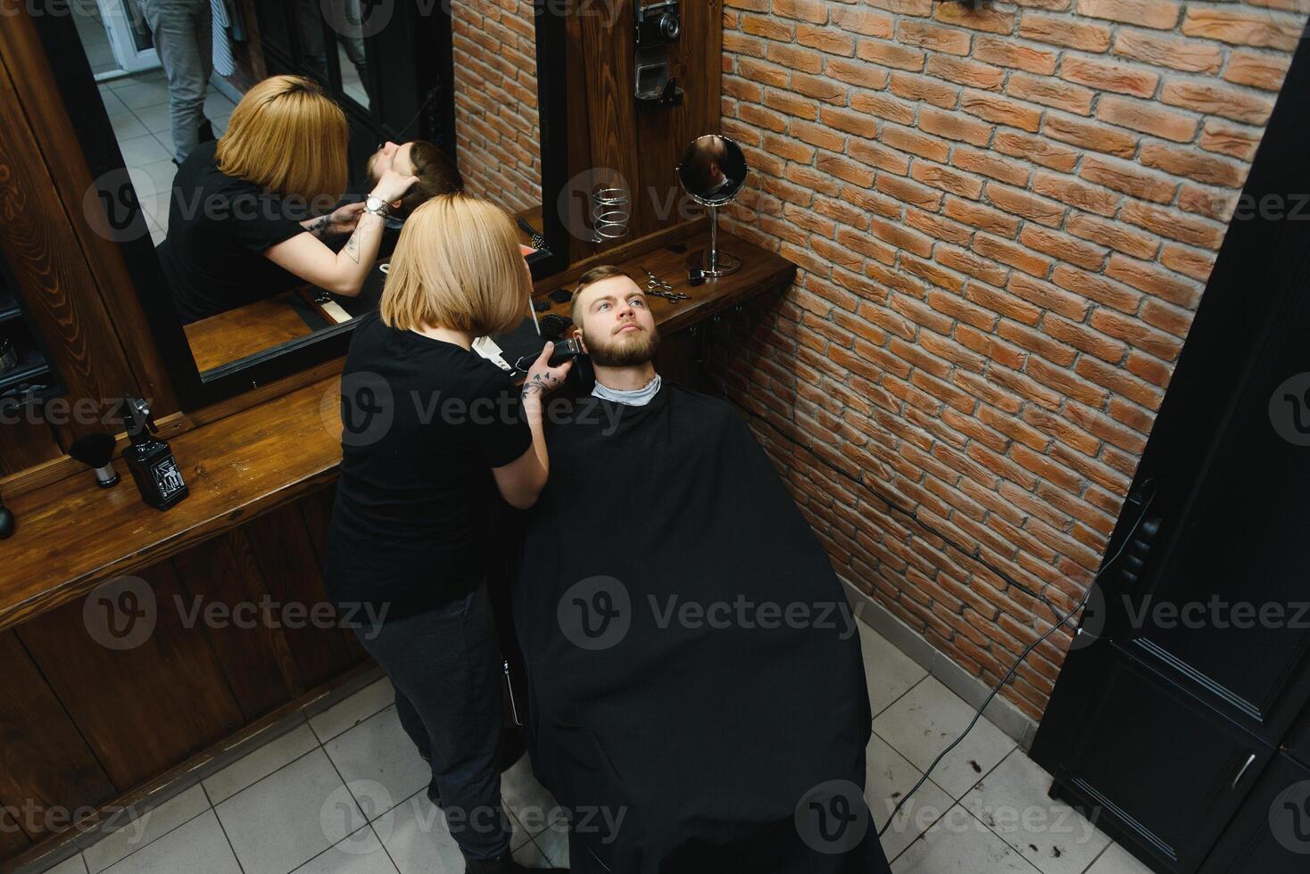 Client during beard shaving in barber shop photo