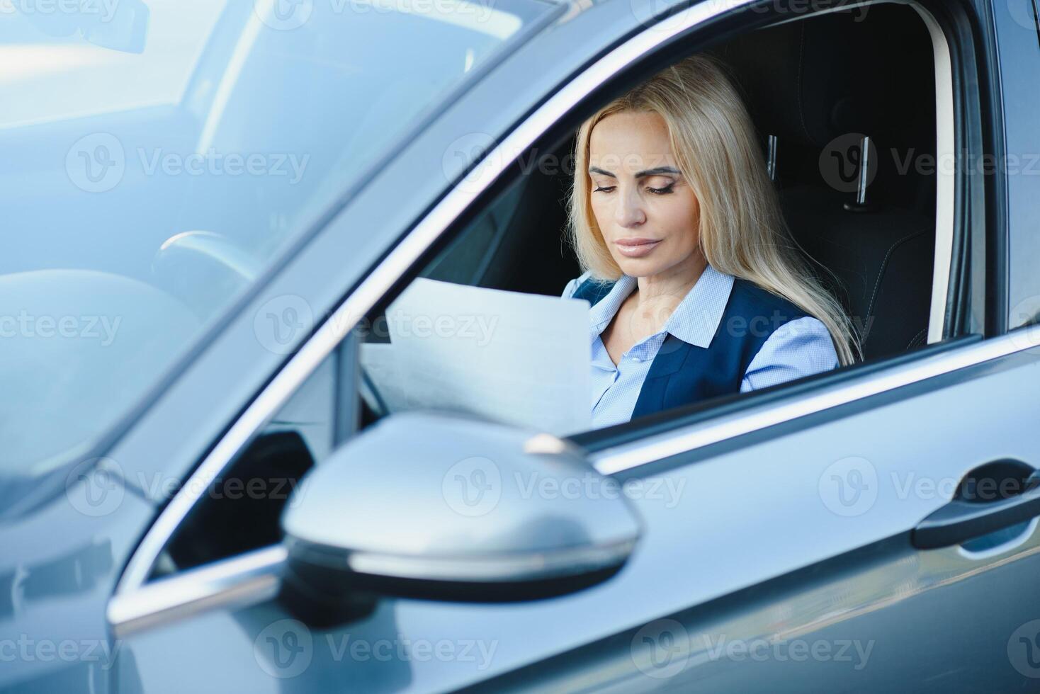Fashion business woman with financial papers by her car photo