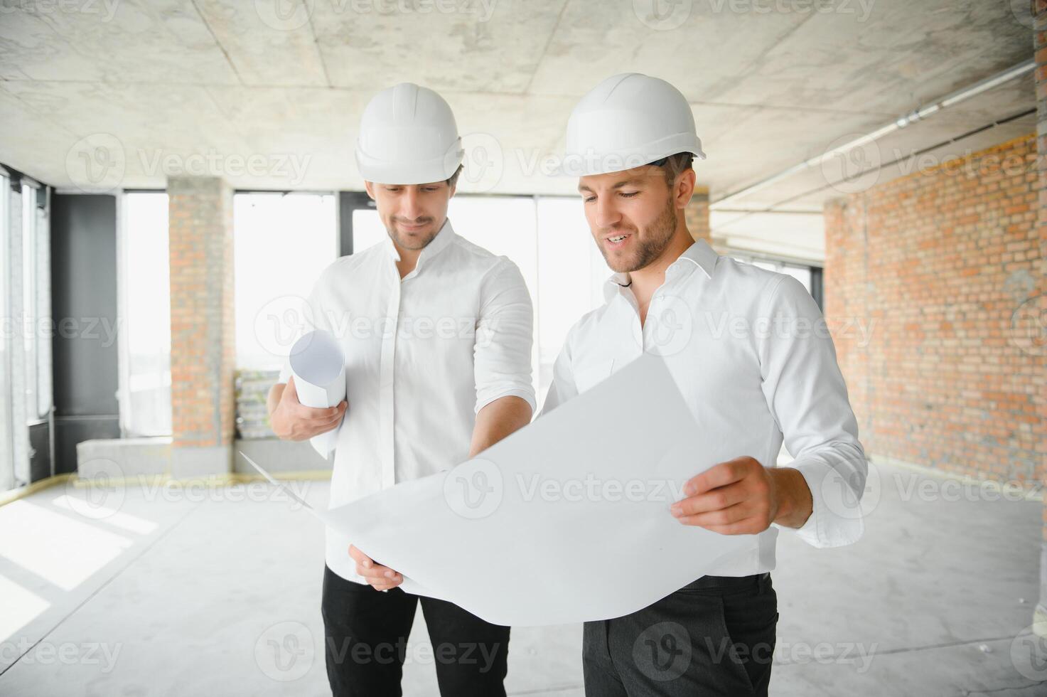 Two civil engineers or architects man inspecting construction of house. photo