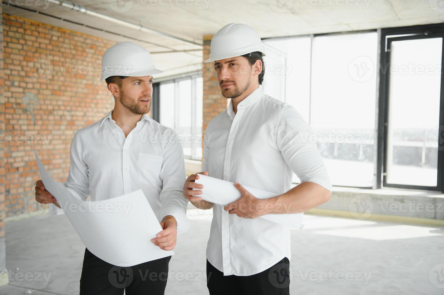 Male Architect Giving Instructions To His Foreman At Construction Site. photo