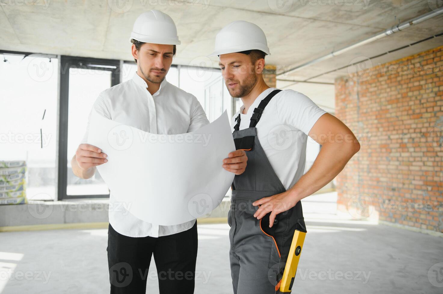 Male Architect Giving Instructions To His Foreman At Construction Site. photo
