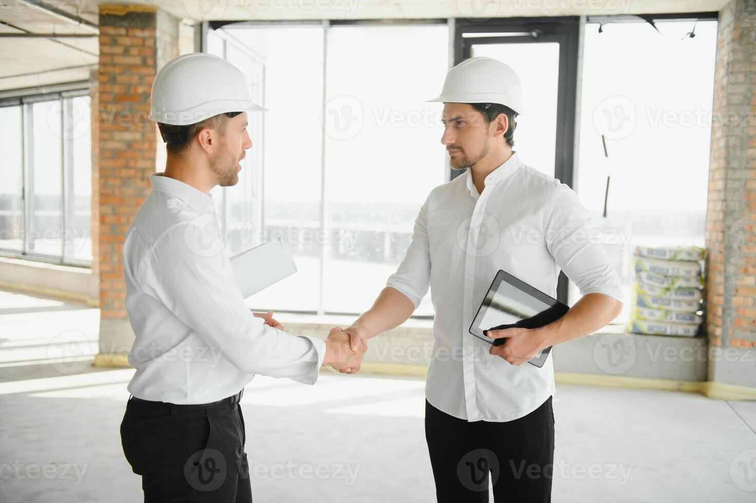 Two young man architect on a building construction site photo