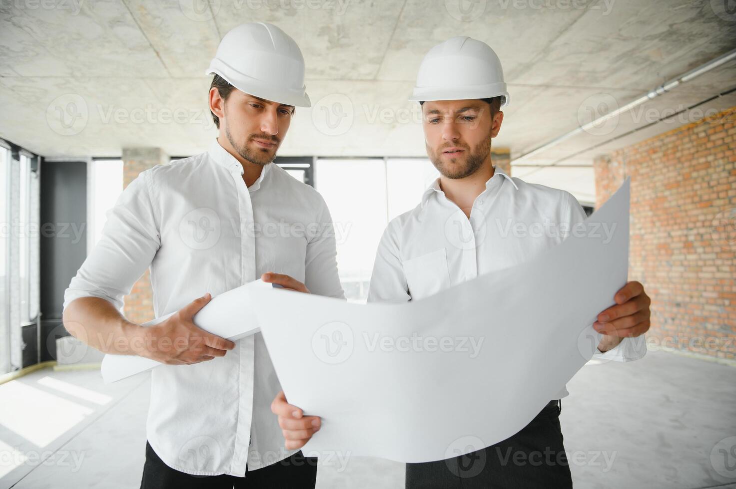 Two Specialists Inspect Commercial, Industrial Building Construction Site. Real Estate Project with Civil Engineer photo